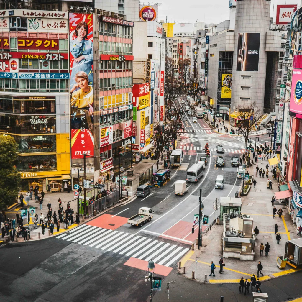 Calle de Tokio con carteles luminosos y tráfico
