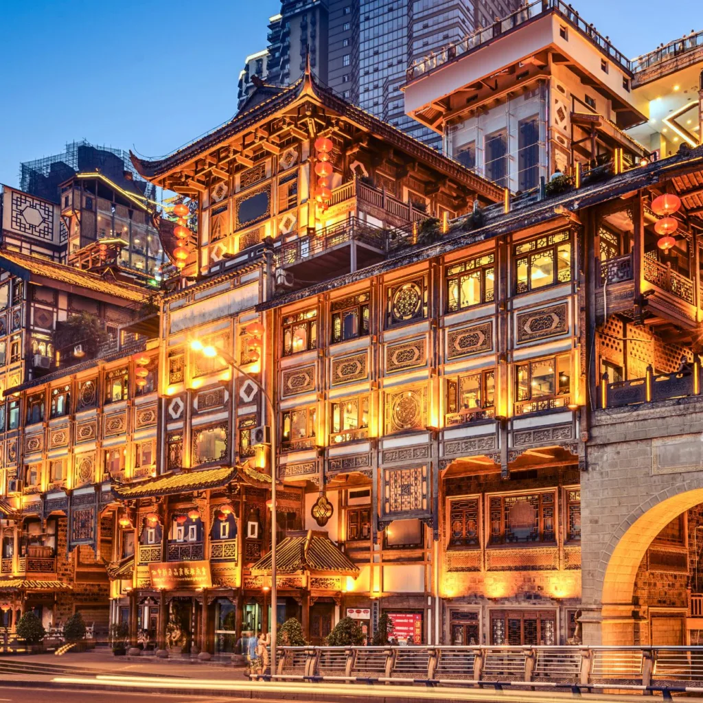 Hongyadong iluminado de noche sobre el río en Chongqing