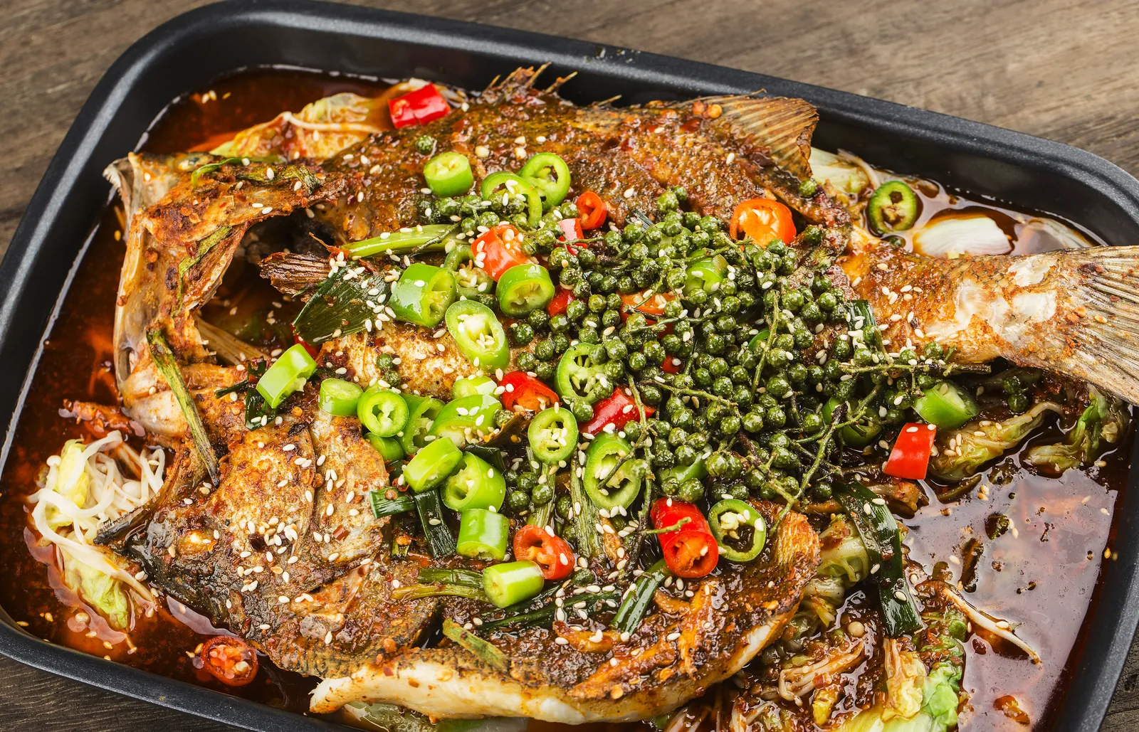 Kaoyu, pescado entero a la brasa en bandeja con caldo picante y pimienta de Sichuan