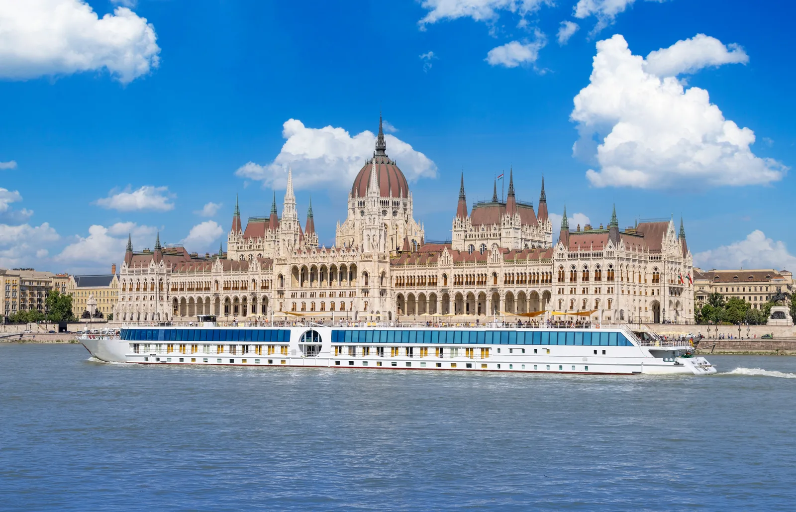 Un barco turístico navega por el Danubio delante del Parlamento de Budapest