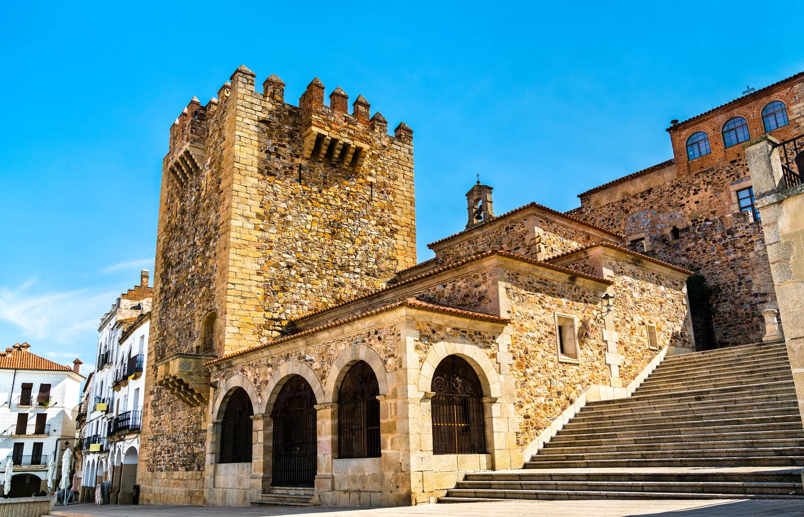 La Torre de Bujaco de Cáceres junto a la escalinata, con los arcos de la Ermita de la Paz a sus pies