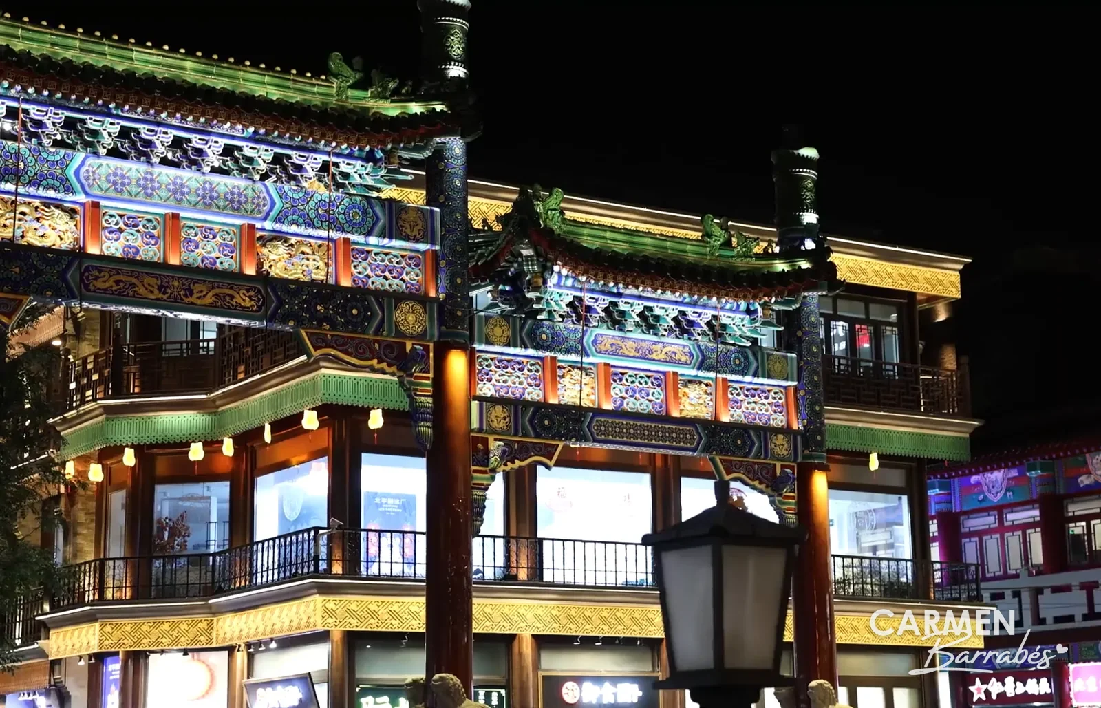 Calle peatonal de Qianmen de noche, con las fachadas tradicionales pintadas e iluminadas
