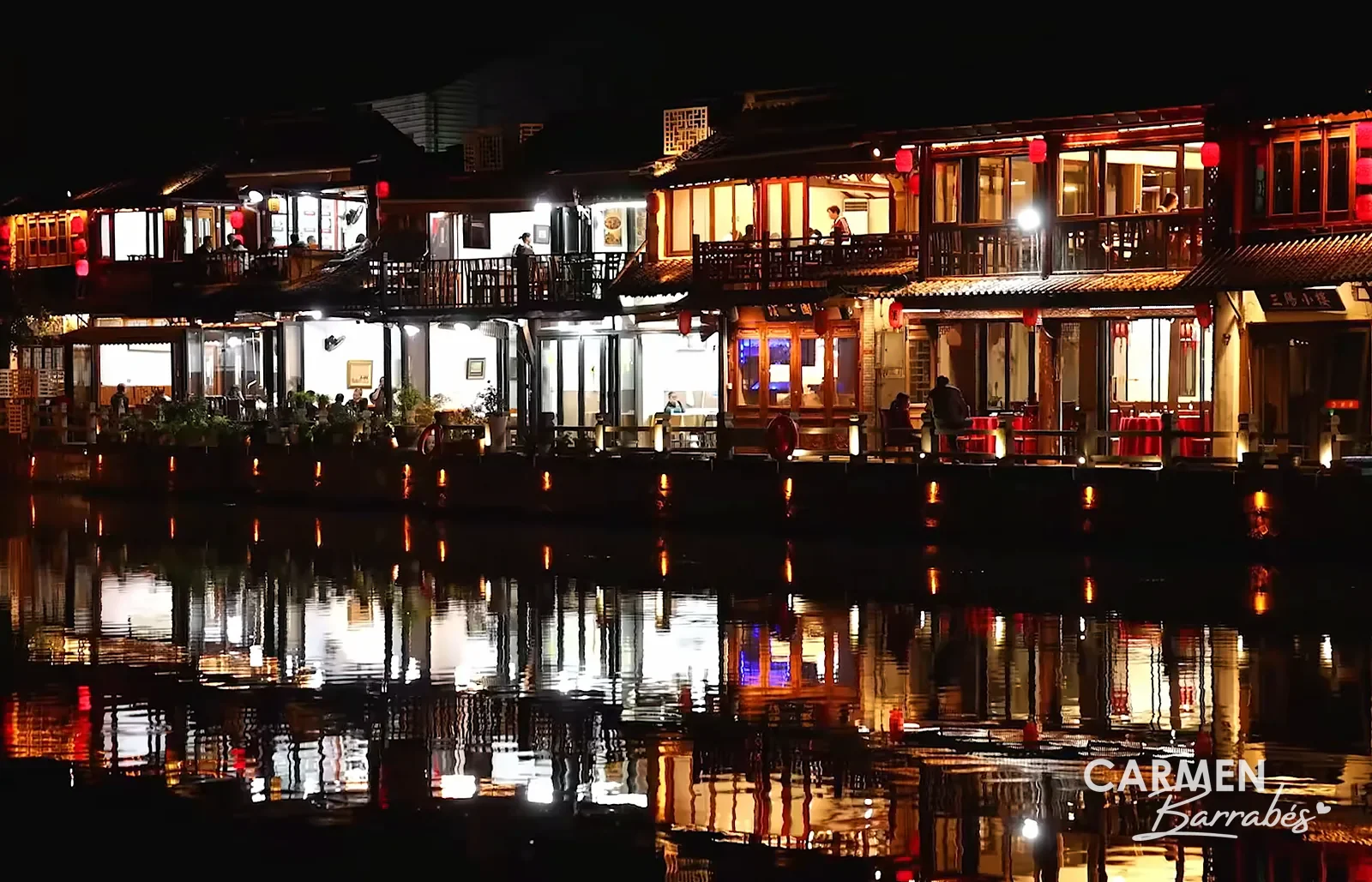 Casas de Zhujiajiao iluminadas de noche y reflejadas en el canal
