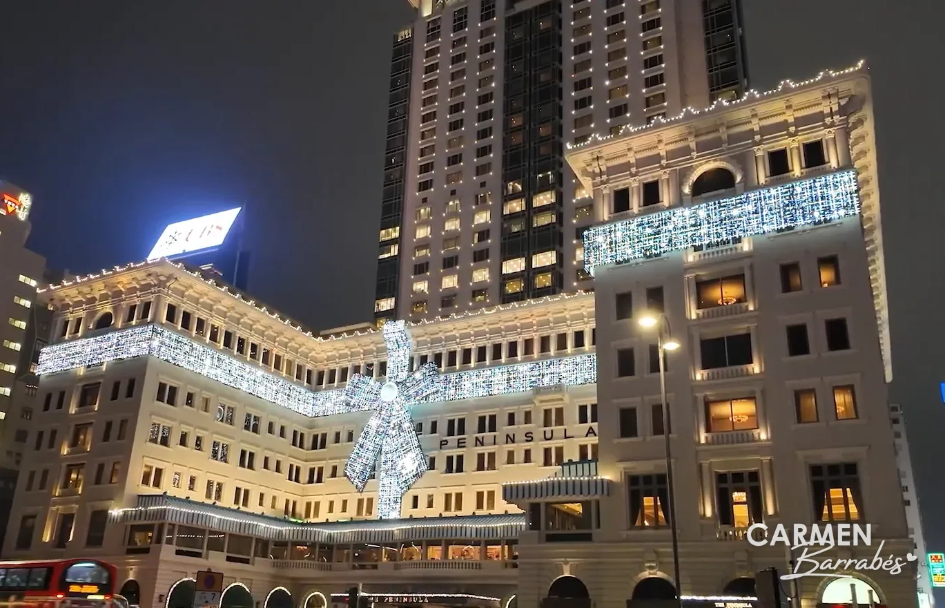 Fachada del hotel The Peninsula en Tsim Sha Tsui, iluminada con un gran lazo de Navidad
