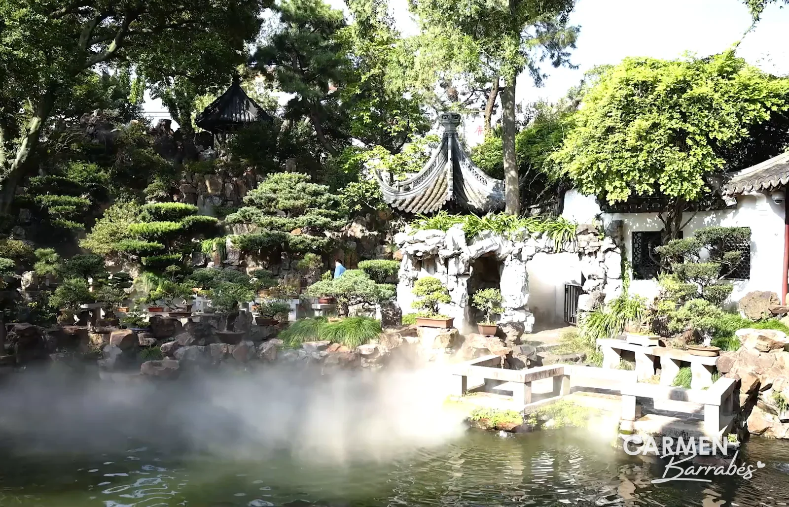 Estanque del Jardín Yuyuan con niebla, rocas y un pabellón entre los árboles