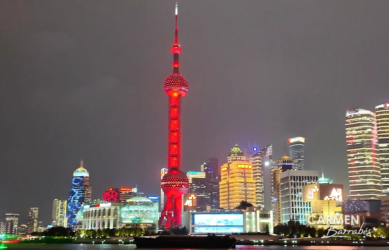 La Perla de Oriente iluminada en rojo, vista de noche desde el Bund al otro lado del río Huangpu