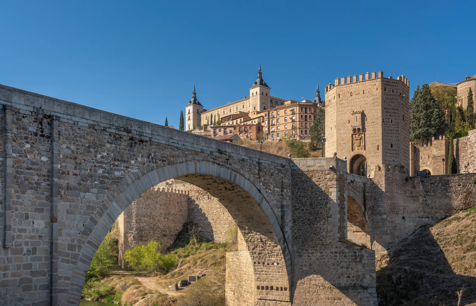El Puente de Alcántara sobre el Tajo con el Alcázar de Toledo al fondo