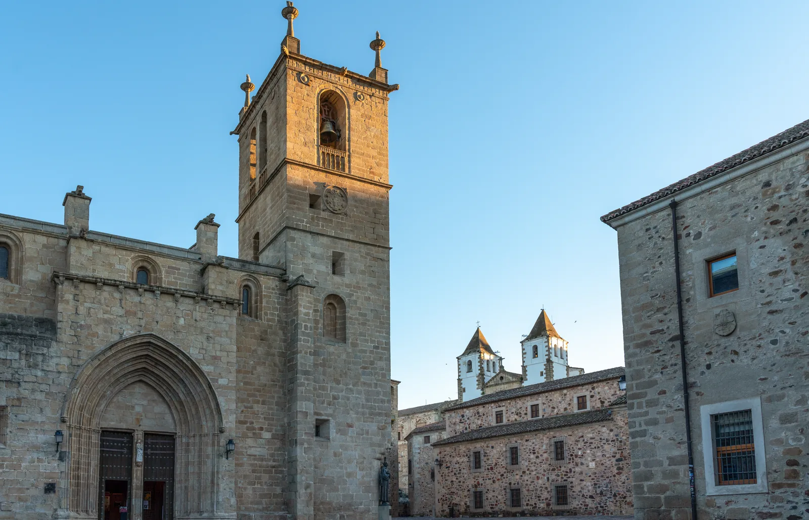 La Concatedral de Santa María de Cáceres con su torre de piedra y, al fondo, las dos torres blancas de la Preciosa Sangre